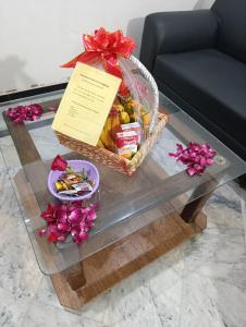 a basket of fruit on a coffee table with flowers at Alnoor Lodgings in Rabwāh