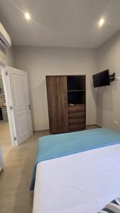a bedroom with a bed and a tv and a door at Casa Vacanza Palazzo Monacelli 1 in Torre del Greco