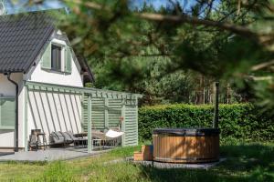 a deck with chairs and a trash can next to a house at LAS i MORZE in Czarny Młyn
