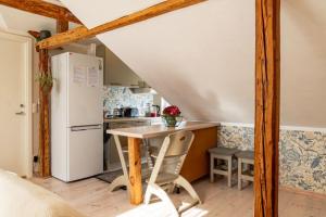 a kitchen with a table and a refrigerator at Hygge Home - Bright Cottage-Style Apartment with Terrace & Free Weekend parking in Tartu