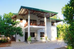 a large white building with a balcony at Prabha Garden Boutique Villa in Anuradhapura