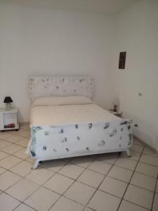 a bed in a white room with a white floor at Fosso Marchese in Cusano Mutri