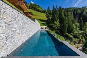 a swimming pool in the side of a brick wall at Mountain Village Hasenegg in Schenna