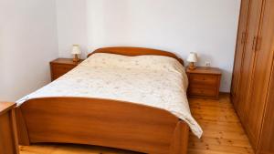 a bedroom with a wooden bed with two night stands at Hisa pri Ovcicevih in Komen