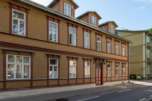 a wooden building with many windows on a street at Hygge Home - Bright Cottage-Style Apartment with Terrace & Free Weekend parking in Tartu