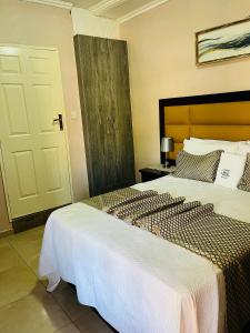 a bedroom with two beds and a door in it at Ledula Guesthouse in Ramotswa