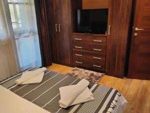 a bedroom with a bed with two napkins and a tv at STADIUM 2 Apartments Sandanski in Sandanski