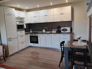 a kitchen with white cabinets and a table in it at STADIUM 2 Apartments Sandanski in Sandanski