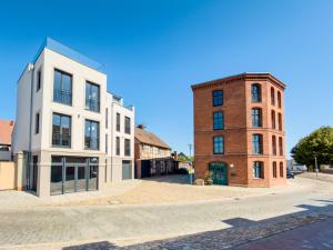 an empty street with two buildings and a brick building at ELBE6 Apartments in Wittenberge