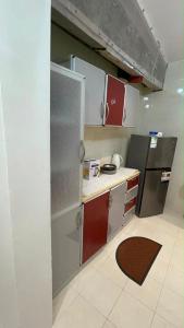a small kitchen with white cabinets and a refrigerator at شاليه الكوثر in Al Baha