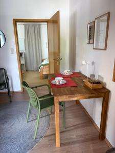 a dining room table with a green chair and a room at Lorenzo Apartments 05 in Burglengenfeld