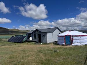 a yurt and a house with a solar panel at Mongolian traditional house Ger in Dzuunmod