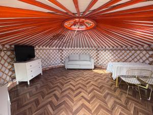 a room with a yurt with a chair and a tv at Mongolian traditional house Ger in Dzuunmod +8 photos