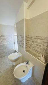 a white bathroom with a sink and a toilet at Linoq in Montepagano