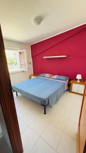 a bedroom with a bed with a red wall at Linoq in Montepagano +22 photos
