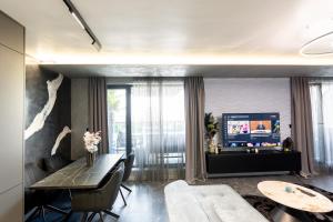 a living room with a table and a television at Beni Deluxe 2 in Plovdiv