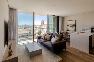 a living room with a couch and a large window at The Downtown Largo do Carmo in Faro