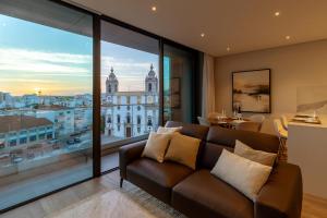 a living room with a couch and a large window at The Downtown Largo do Carmo in Faro