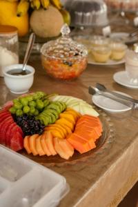 a plate of fruit and vegetables on a table at Pousada Tropical Ilhas in Aquiraz +25 photos
