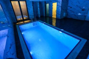 an indoor swimming pool in a house with blue lighting at Jizzax Hotel Tashkent in Tashkent