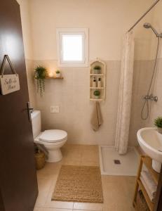 a bathroom with a toilet and a sink and a window at Raha-26 in Al Ghar