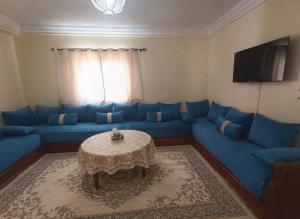a living room with a blue couch and a table at Raha-26 in Al Ghar