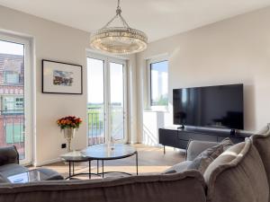 a living room with a couch and a flat screen tv at ELBE6 Apartments in Wittenberge