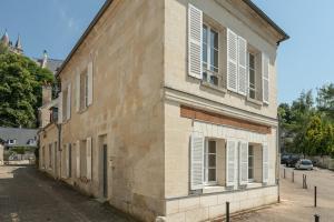 an old building with white shutters on a street at Maison Sophie for 10 guests in Pierrefonds