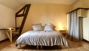 a bedroom with a large bed with white sheets and pillows at Maison d'hôtes- éco tourisme in Moux-en-Morvan