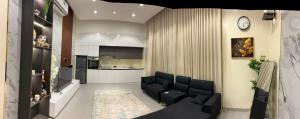 a living room with a couch and a kitchen at JebelStay in Al Ḩamrāʼ