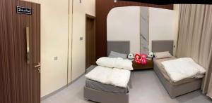 a room with two beds and a mirror at JebelStay in Al Ḩamrāʼ +4 photos