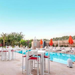a row of tables and chairs next to a swimming pool at Palais Jena Hotel & Spa in Marrakesh