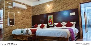 a hotel room with two beds with red pillows at Anbu Grand Inn in Chidambaram