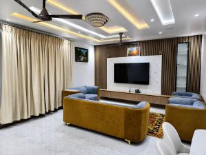 a living room with a couch and a flat screen tv at the urban escape in Kwabenyan