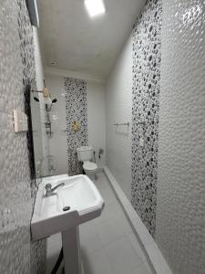 a white bathroom with a sink and a toilet at Nuwanma in Halpatota