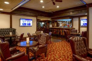a restaurant with tables and chairs and a bar at Coast Prince George Hotel in Prince George