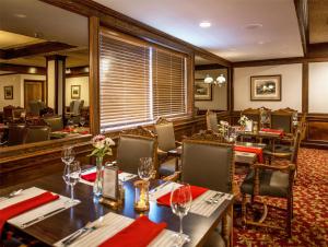 a restaurant with tables and chairs with red napkins at Coast Prince George Hotel in Prince George