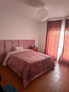 a bedroom with a large bed with a pink blanket at Casa Lena in Vagos
