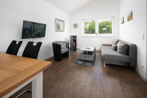 a living room with a couch and a table at Chalets im Landhotel Pferdeschulze in Hitzacker