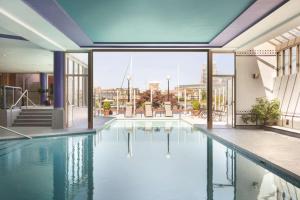 a pool in a building with a view of the city at Coast Victoria Hotel & Marina by APA in Victoria