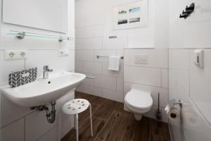 a white bathroom with a sink and a toilet at Chalets im Landhotel Pferdeschulze in Hitzacker