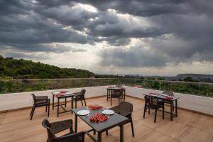 a patio with tables and chairs on a balcony at Nivaara by GHD Hotels in Nerul