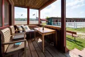 a screened in porch with a table and a bench at Chalets im Landhotel Pferdeschulze in Hitzacker