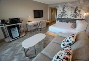 a living room with a couch and a bed at Coast Victoria Hotel & Marina by APA in Victoria