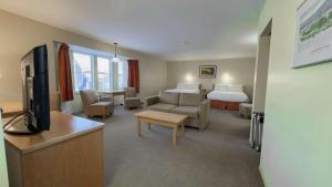 a hotel room with a bed and a living room at Eldorado, a Coast Hotel in Dawson City