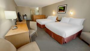 a hotel room with two beds and a couch at Eldorado, a Coast Hotel in Dawson City