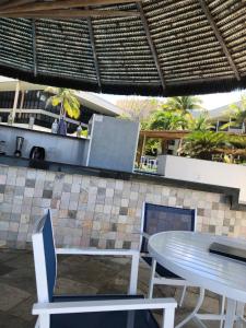 a patio with a table and chairs and palm trees at Pirâmide Palace Hotel in Natal +5 photos
