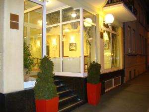 a store with two potted plants in front of a building at Hotel Vila Ariston in Osijek