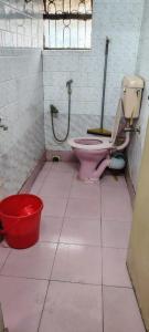 a bathroom with a pink toilet and a red bucket at Anand Vihar in kolkata