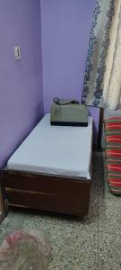 a bed with a suitcase sitting on top of it at Anand Vihar in kolkata